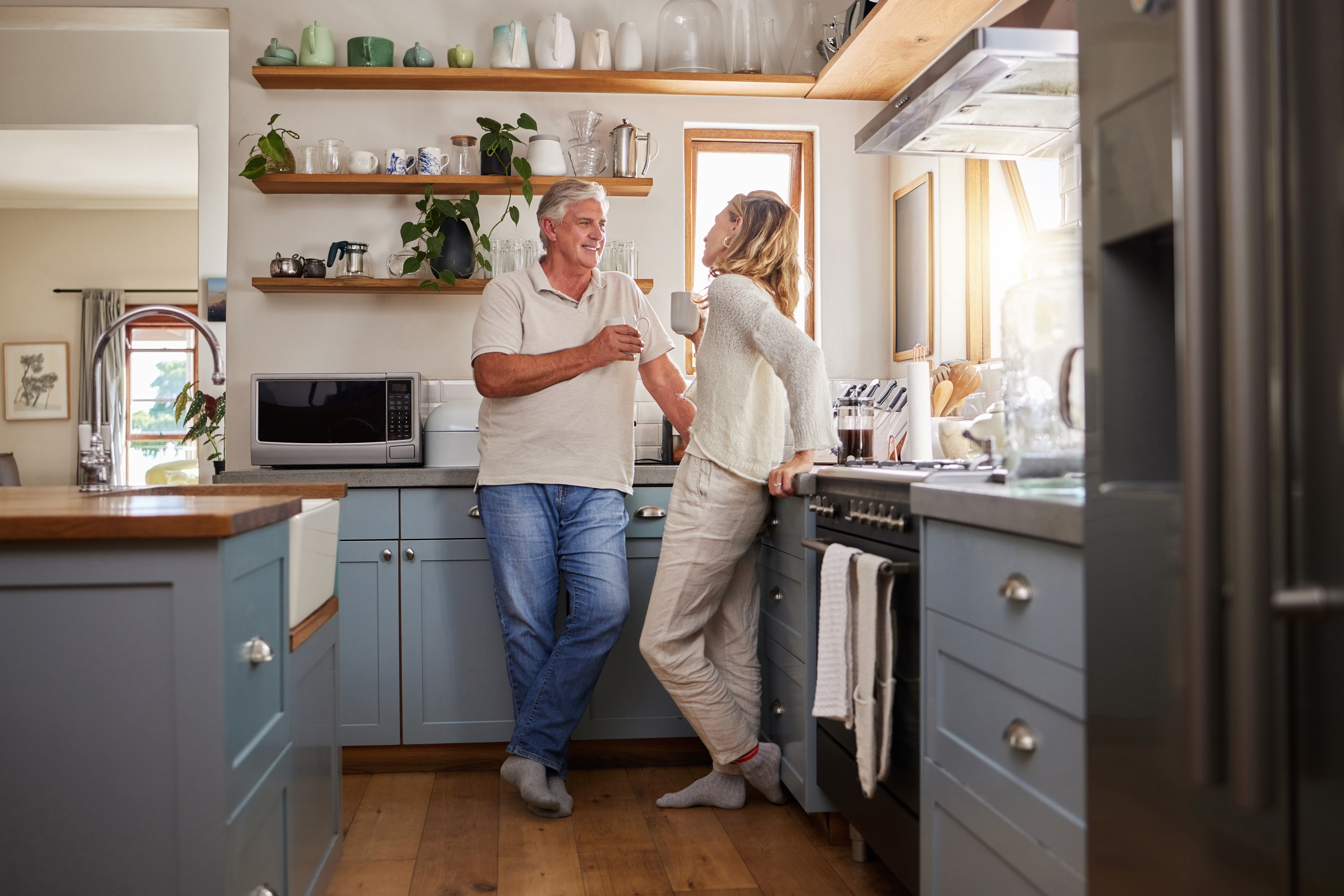 older couple in kitchen drinking coffee