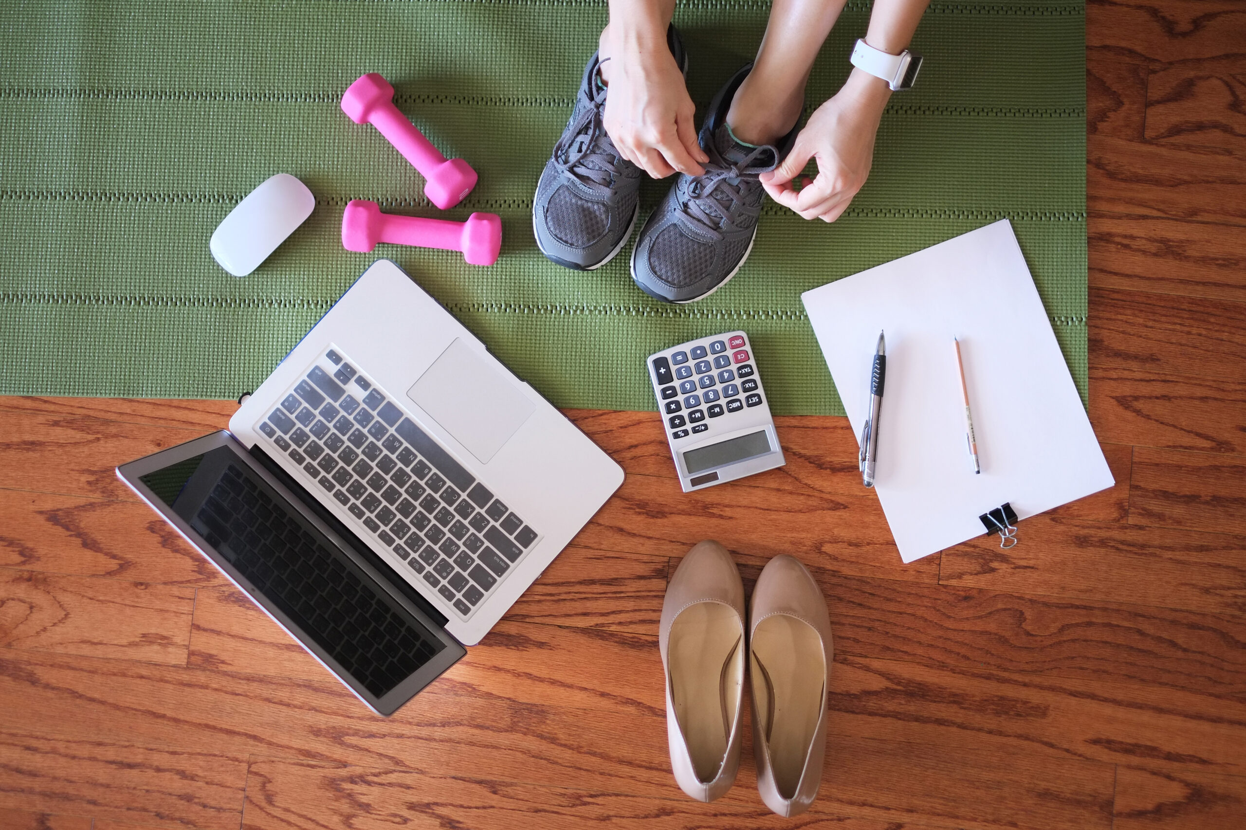 woman work and workout at home for healthy concept and work-life balance. With laptop and small dumbbells.