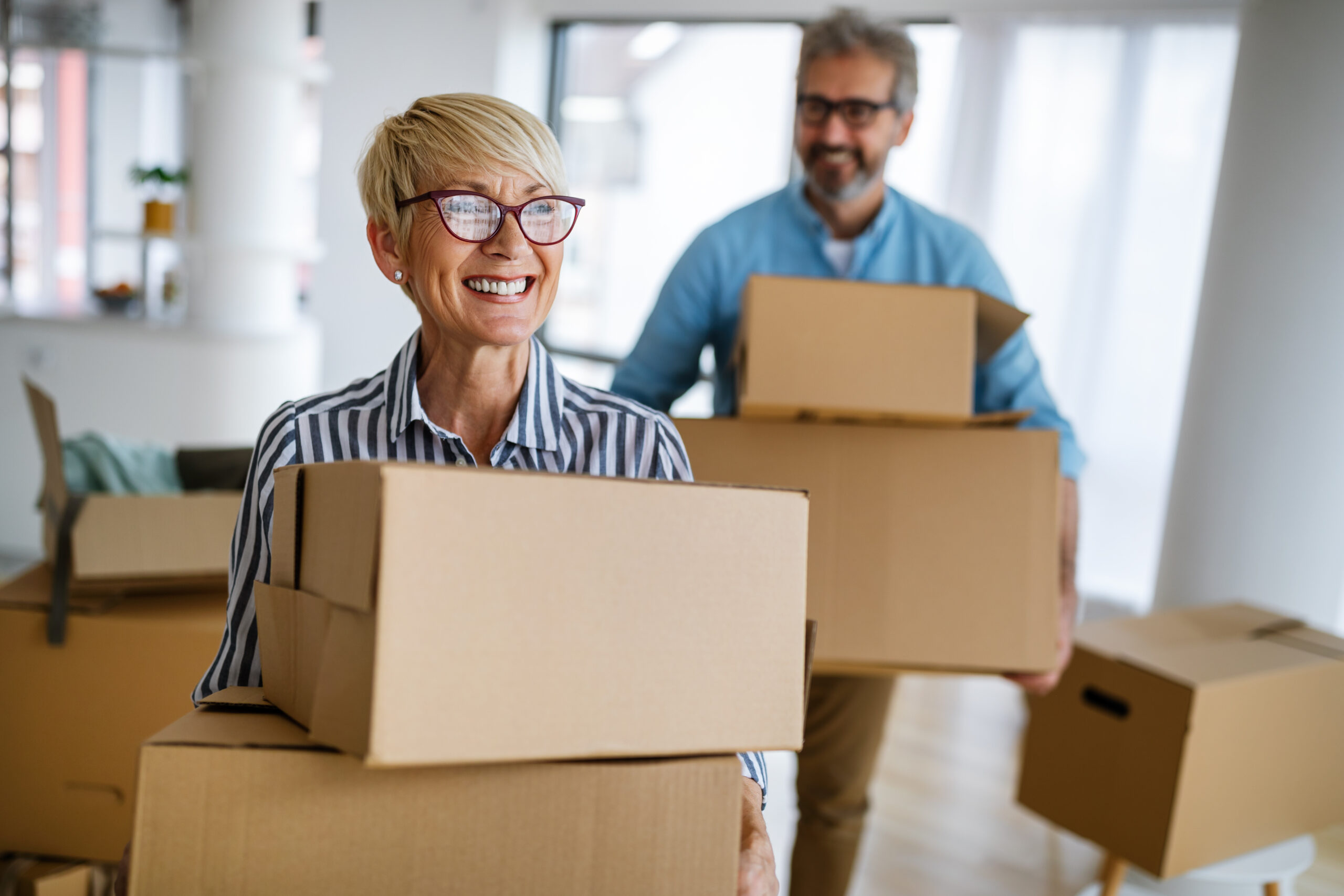 Portrait of happy smiling senior couple in love moving in new home, downsizing in retirement